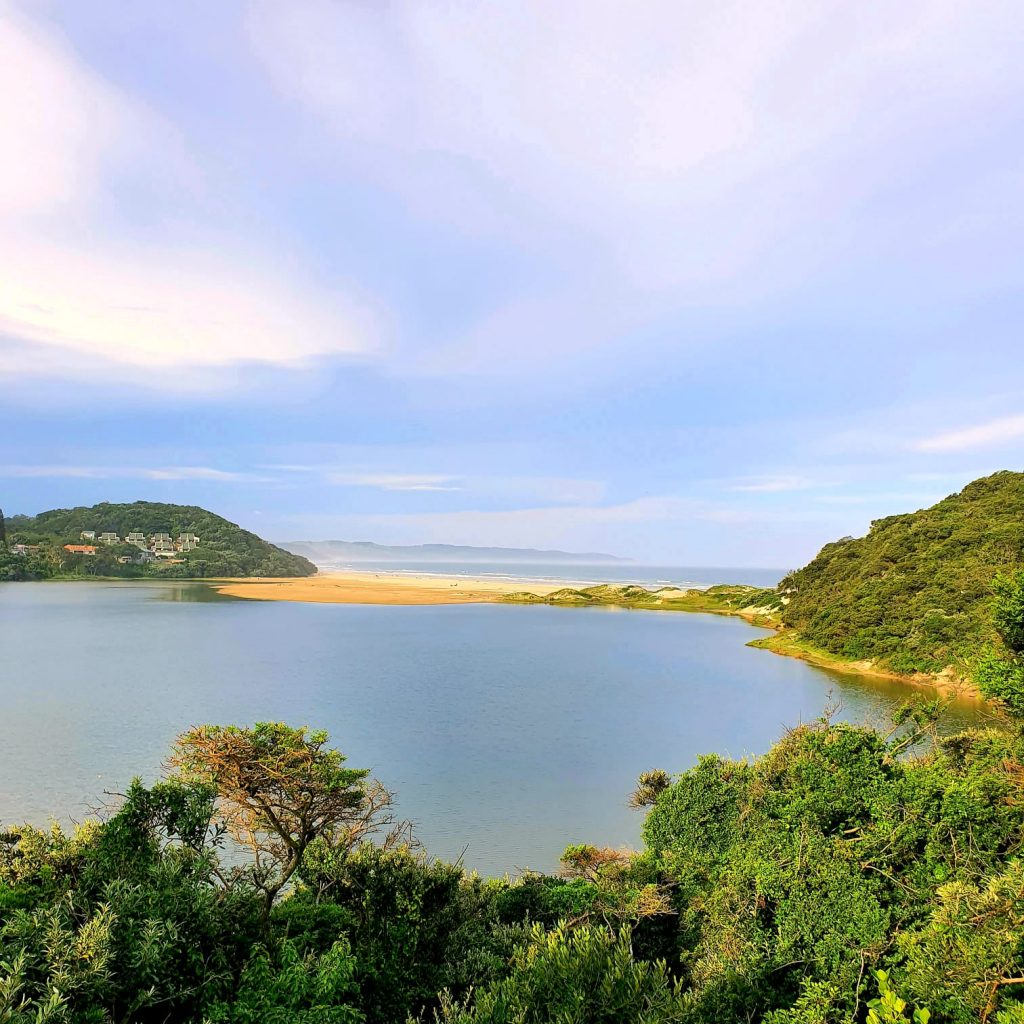 A sheltered estuary, sandbank and wooded coastal slopes