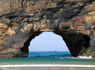 The rock arch at Hole in the Wall framing turquoise sea
